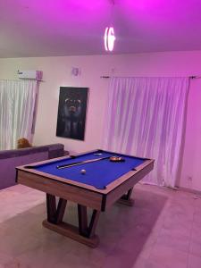 una mesa de billar en una sala de estar con iluminación púrpura en Villa Dakar 200 m plage, en Dakar