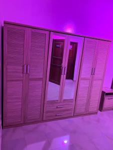 una fila de armarios de madera en una habitación púrpura en Villa Dakar 200 m plage, en Dakar