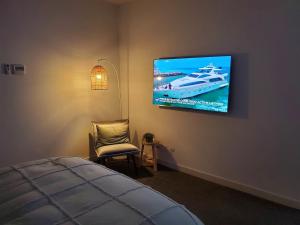 a bedroom with a bed and a tv on the wall at The View in Safety Beach