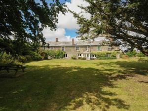 a large stone house with a picnic table in the yard at Lee Barton Farmhouse in Bude