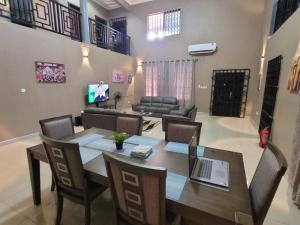 a dining room with a table with a laptop on it at Stylish House with Generator - Tema Community 25 in Hanya