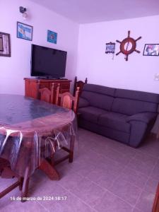 salon z kanapą, stołem i telewizorem w obiekcie Alquiler Jano w mieście Tecka