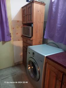 una lavatrice in una cucina con forno a microonde di Alquiler Jano a Tecka
