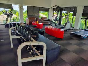 un gimnasio con varias cintas de correr y máquinas de ejercicio en Friend's House en Bangkok