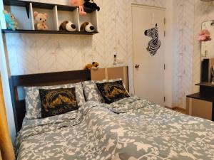 1 dormitorio con 1 cama con edredón gris y blanco en Friend's House en Bangkok