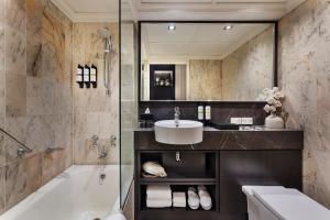 奥克兰Pullman Auckland Hotel & Apartments的带浴缸、水槽和镜子的浴室