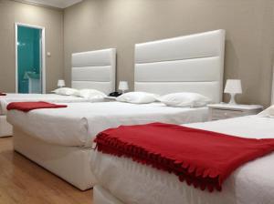 Dos camas en una habitación con rojo y blanco. en Royal Porto City, en Oporto