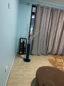 ein Zimmer mit einer Vase auf dem Boden und einem Fenster in der Unterkunft Jay Apartments in Mbarara