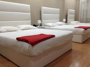 1 dormitorio con 2 camas y toallas rojas. en Royal Porto City, en Oporto