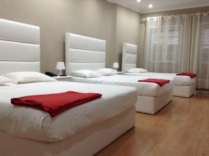 1 dormitorio con 3 camas con almohadas rojas. en Royal Porto City, en Oporto