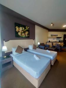 two beds in a room with a living room at Rainbow Paradise BeachFront Penang in Tanjung Bungah
