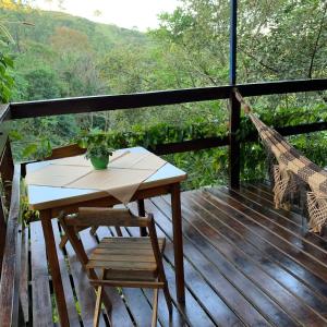 una mesa y sillas en una terraza con vistas en Chalé aconchego, en Santo Antônio do Pinhal
