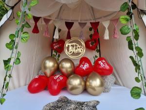 a group of red and gold balloons in a tent at Levit Glamping - Hotel Guatapé Peñol in Guatapé