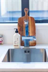 a bottle of soap sitting on top of a sink at Stylish 2-Bedroom Haven Next to Hagley Park in Christchurch