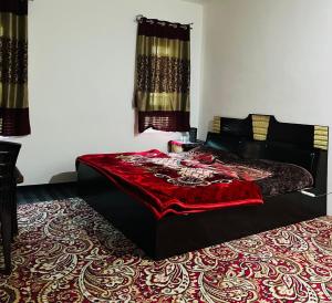 a bedroom with a bed with a red blanket on it at Sunset View Gulmarg in Gulmarg