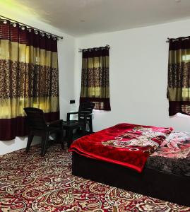 a bedroom with a bed and chairs and curtains at Sunset View Gulmarg in Gulmarg