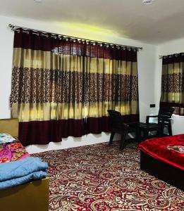 a bedroom with a bed and a window with curtains at Sunset View Gulmarg in Gulmarg