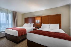 a hotel room with two beds and a window at Comfort Suites in Bowling Green