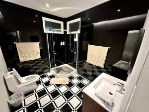 a black and white bathroom with a shower and a sink at Cape House in Ban Bang Kaeo