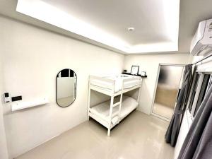 a white room with a mirror and a shelf at Cape House in Ban Bang Kaeo
