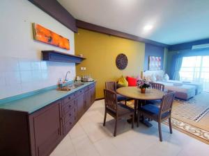 a kitchen with a table and a living room with a couch at Jazz Rainbow Paradise beachfront Peanag in Tanjung Bungah