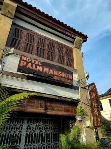 un bâtiment avec un panneau indiquant la gestion de l'hôtel dans l'établissement Palm Mansion Boutique Suites, à George Town