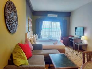 a hotel room with a bed and a couch at Jazz Rainbow Paradise beachfront Peanag in Tanjung Bungah