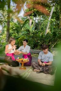 a group of three people sitting around a table at The Artini Dijiwa Ubud in Ubud