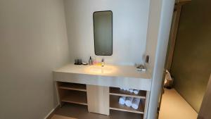 een badkamer met een wastafel en een spiegel bij Arena Cam Ranh Beach resort in Miếu Ông
