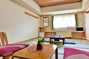 a living room with purple furniture and a table at Shiga Grand Hotel in Yamanouchi