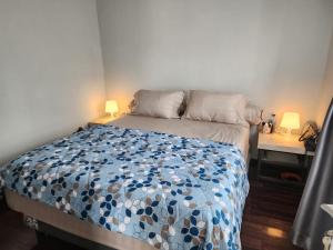 a bedroom with a bed with a blue and white comforter at Porlak Hebron Family Homestay in Siborongborong