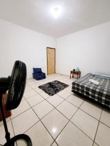 a bedroom with a bed and a tiled floor at Quarto Proença in Campinas