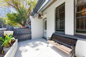 una panchina di legno seduta fuori da una casa di 4 bedroom Haven Spacious Terrace @Bondi Junction a Sydney
