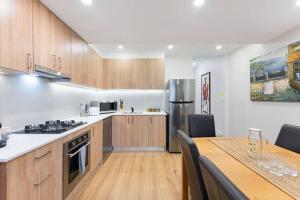 una cucina con armadi in legno, un tavolo e una sala da pranzo di 4 bedroom Haven Spacious Terrace @Bondi Junction a Sydney
