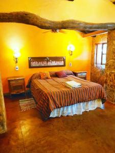 a bedroom with a large bed in a stone room at Cabañas spa el petrel in San Javier