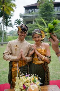 a man and a woman standing in front of a cake at The Artini Dijiwa Ubud in Ubud
