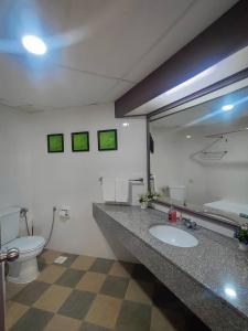 La salle de bains est pourvue d'un lavabo, de toilettes et d'un miroir. dans l'établissement 17 Jazz sweet beachfront resort, à Tanjung Bungah