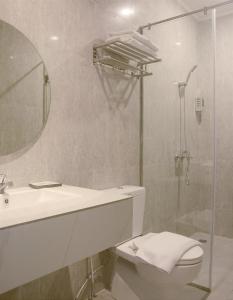 La salle de bains est pourvue d'un lavabo, de toilettes et d'une douche. dans l'établissement Kesuma Front One Boutique Palembang, à Palembang