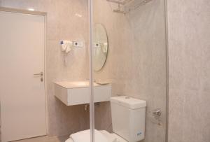 a bathroom with a shower and a toilet and a sink at Kesuma Front One Boutique Palembang in Palembang