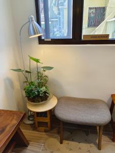 une chambre avec une chaise et une table avec une plante dans l'établissement 日日和, à Tainan