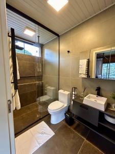 a bathroom with a toilet and a shower and a sink at Vivenda Le Vin em Alfredo Wagner in Barracão