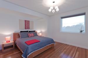 um quarto com uma cama e uma grande janela em Taworri em Queenscliff