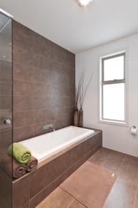 uma banheira na casa de banho com uma janela em Taworri em Queenscliff