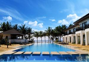 une piscine à côté d'une plage avec des palmiers dans l'établissement Puerto Del Sol Beach Resort and Hotel Club Bolinao Pangasinan, à Bolinao 34 autres photos