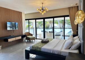 a bedroom with a large bed and a chandelier at Puerto Del Sol Beach Resort and Hotel Club Bolinao Pangasinan in Bolinao