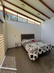 1 dormitorio con 1 cama en una habitación con ventana en Casa de Campo Moderna Ubaté - Sector La Laja, en Ubaté