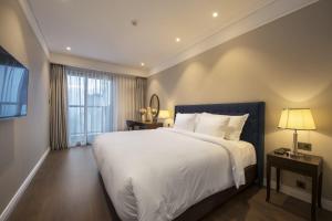 a bedroom with a large white bed and a window at Da Nang Ocean View Luxury Apartment in Da Nang
