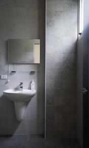 La salle de bains est pourvue d'un lavabo et d'une douche avec un miroir. dans l'établissement 富士A’tolan, à Fushan