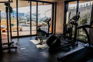 einen Fitnessraum mit Laufbändern und Trainingsgeräten in einem Gebäude in der Unterkunft Modern Wex 831 in Kapstadt