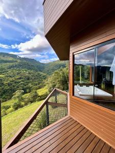 un balcón de una casa con vistas a las montañas en Vivenda Le Vin em Alfredo Wagner en Barracão